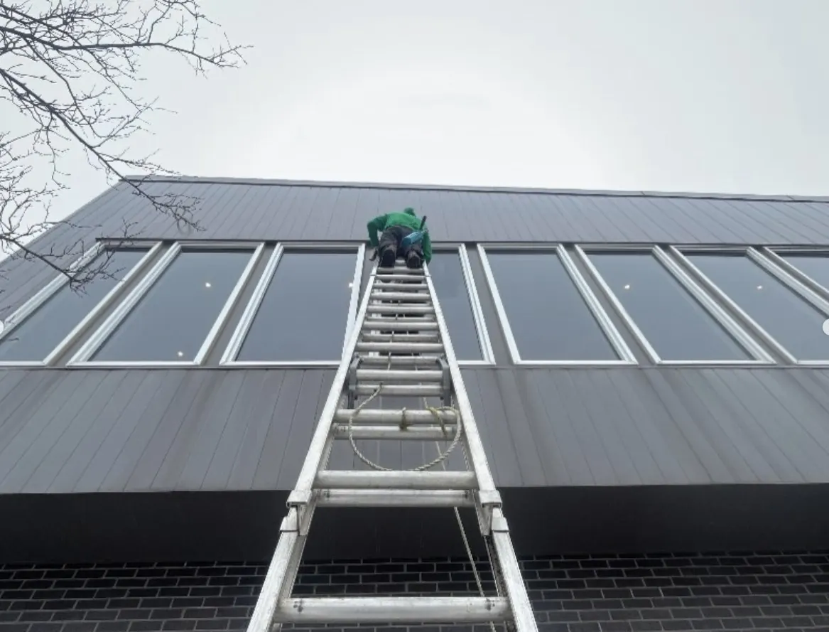 Doering Window Cleaning technician on extension ladder for commercial window cleaning in Guelph